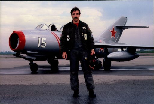 Books by Paul Entrekin, Author of Mr. MiG, posing with his MiG 15 aircraft.